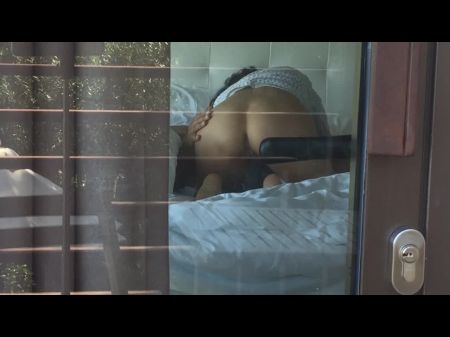 拍摄一对热门夫妇，凝视酒店窗户