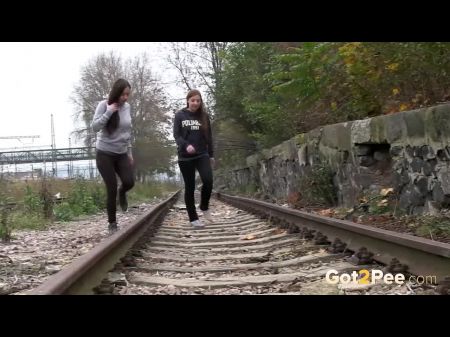 Garotas travessores mijarem perto da ferrovia 