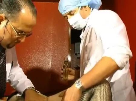 Dois médicos agradando um paciente quente da França com seus galos e ferramentas 
