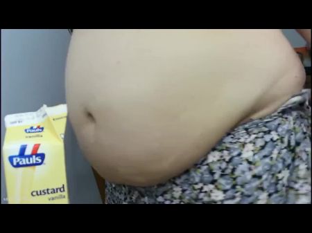 Fettleibige Frau blickt und spielt mit ihrem gigantischen Bauch 