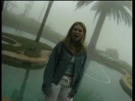 hermosa adolescente rubia con un vestido rojo sexy monta un poste duro y firme en la cama de la playa 