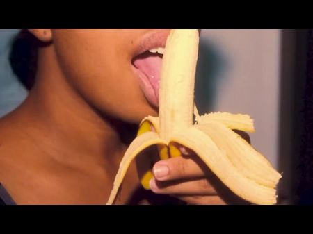 freches Ebenholz mit sexy Lippen spielt mit einer Banane 